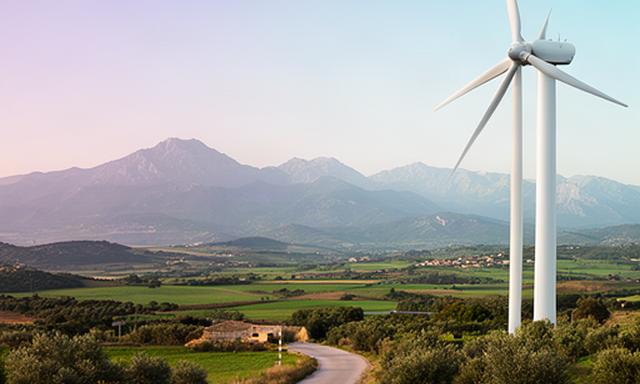 Aerogenerador de Baix Empordà Aerogeneradores S.L. junto a una carretera rural de Llagostera, con las montañas de Cataluña al fondo